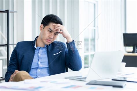 精神紧张的商人从事笔记本电脑工作在商业损失后头痛在办公室背景中英俊的行政人员沮丧高清图片下载-正版图片307950991-摄图网