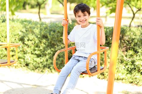 可爱的小男孩在公园里荡秋千高清图片下载-正版图片504572743-摄图网