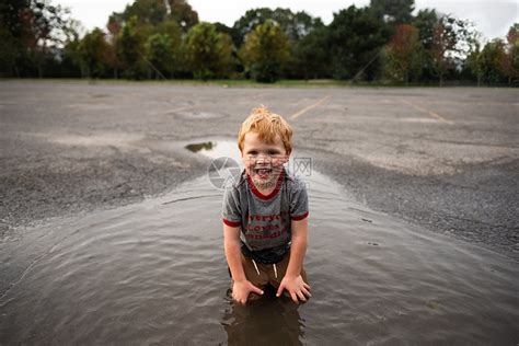 男孩在路上跪水坑里高清图片下载-正版图片501888041-摄图网