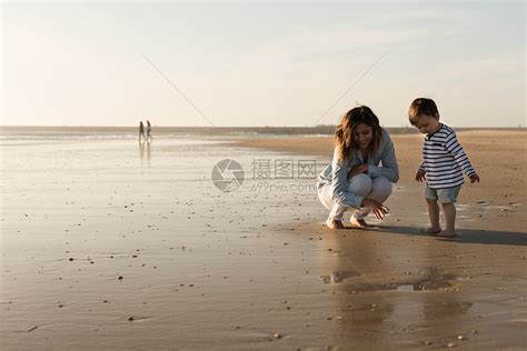 妈妈蹒跚学步的孩子海滩上轻的母亲蹒跚学步的孩子探索海滩高清图片下载-正版图片300133535-摄图网